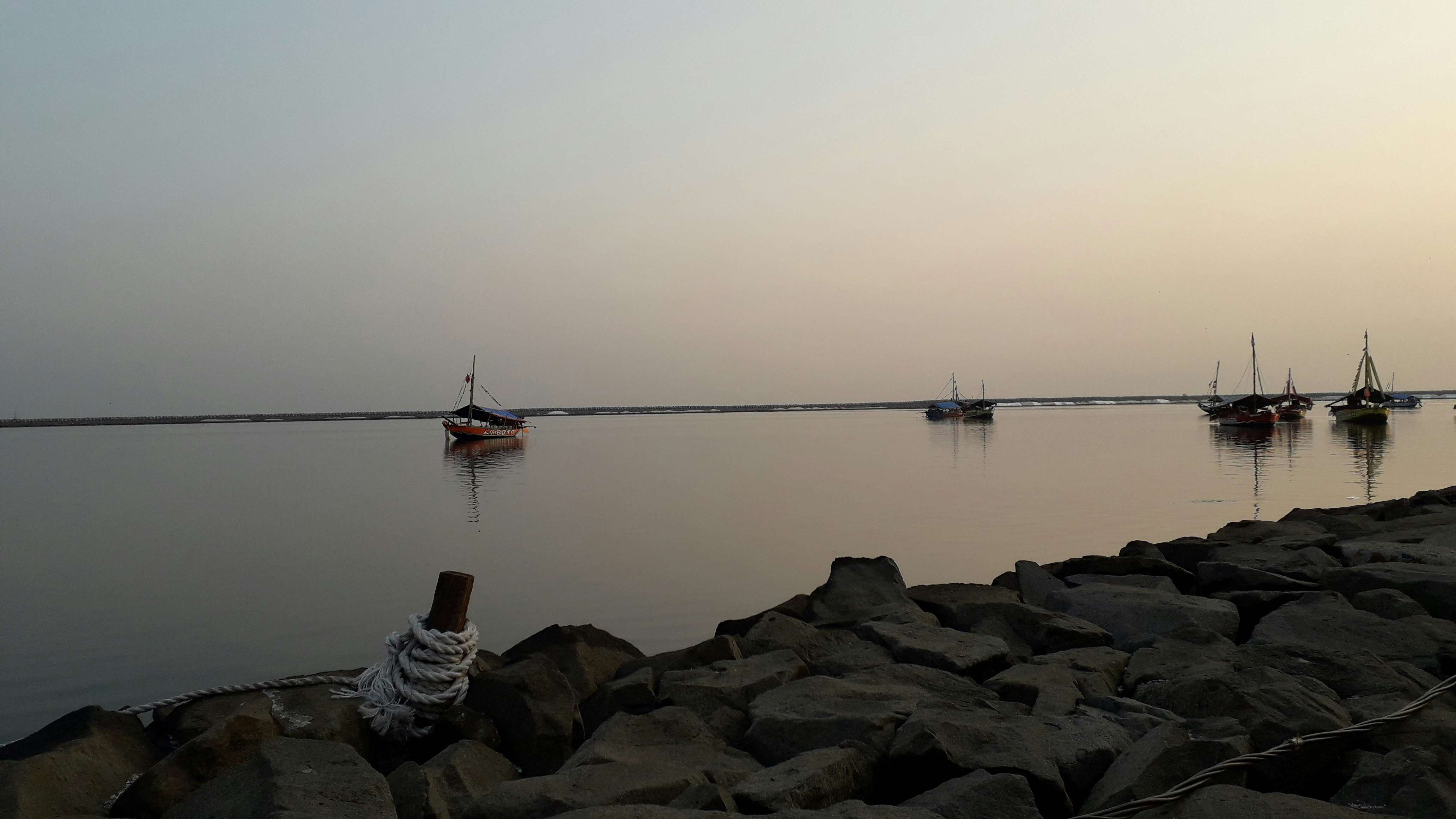a group of boats floating on top of a body of water