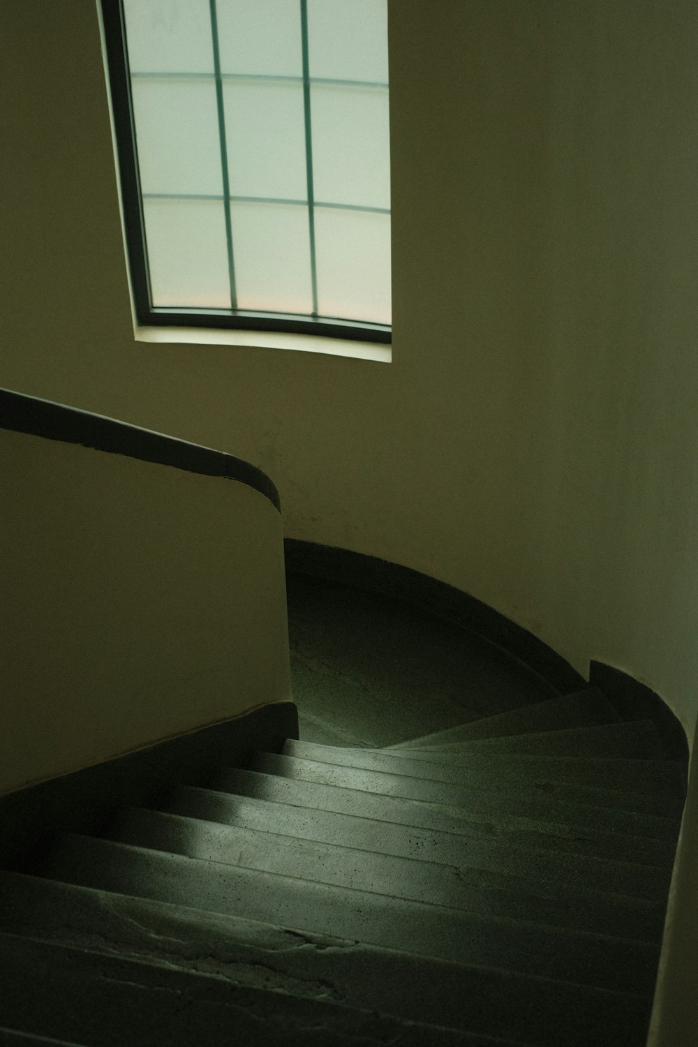 a spiral staircase leading to a window in a building