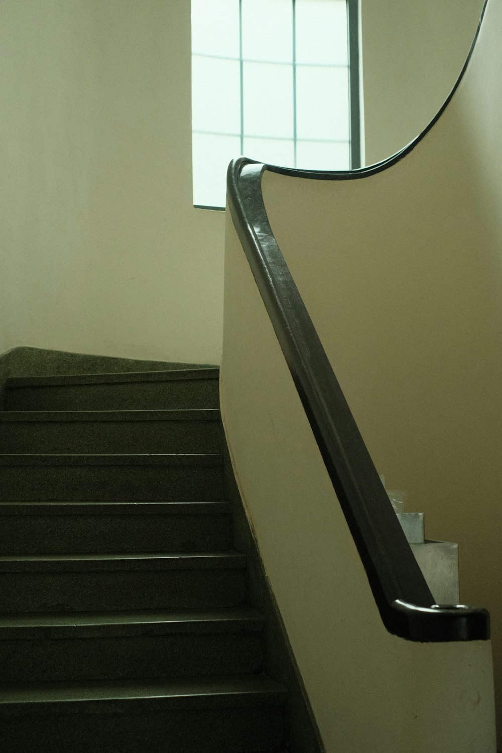 a staircase with a mirror on the wall above it