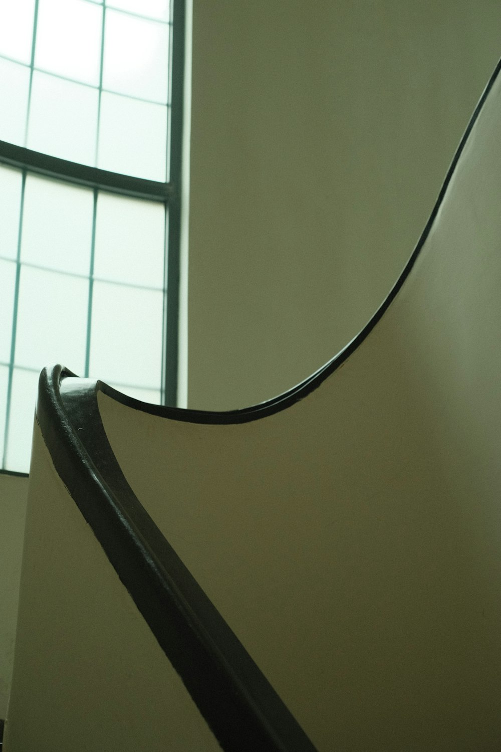 a close up of a curved metal object near a window