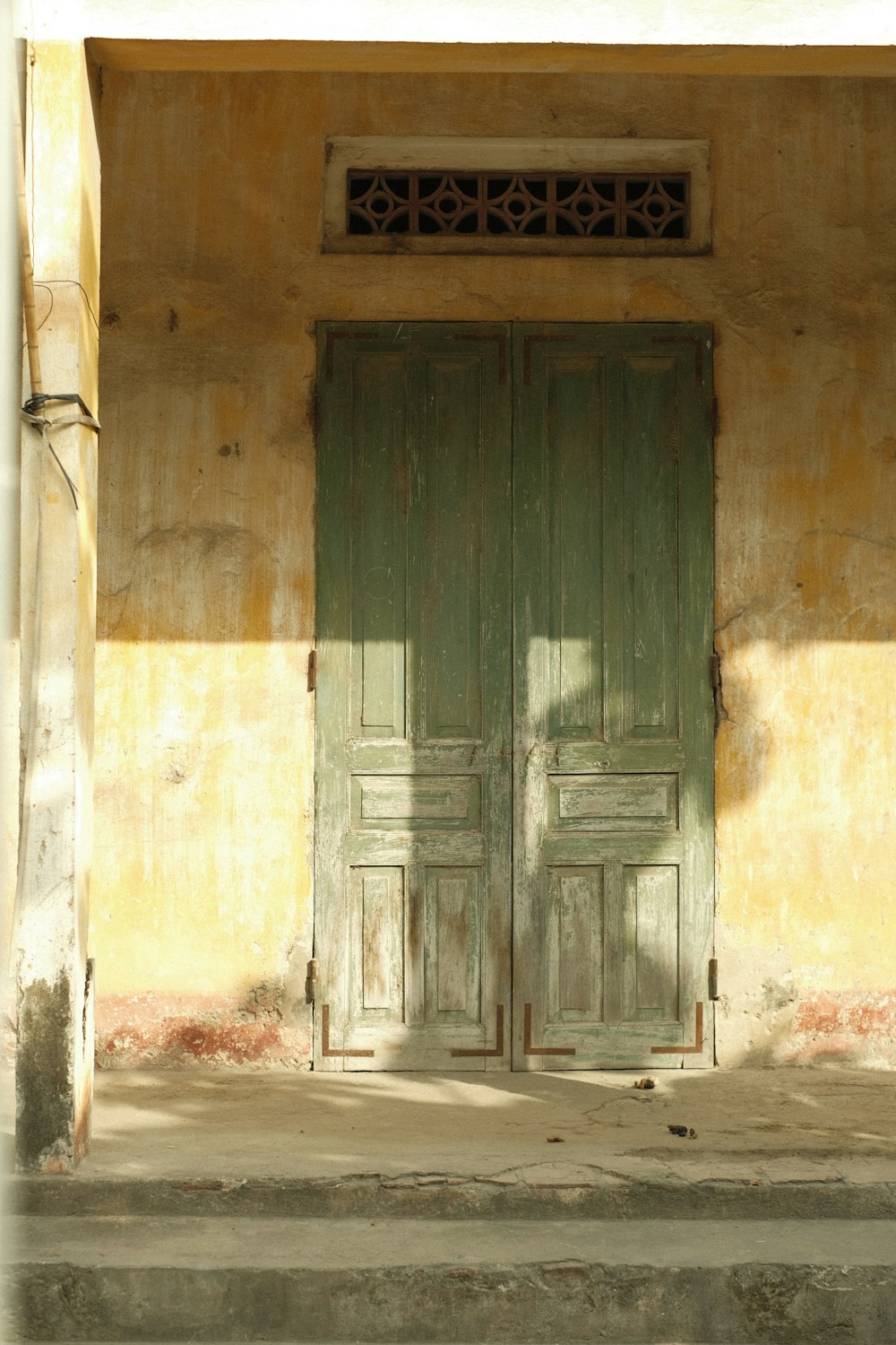 a couple of green doors sitting on the side of a building