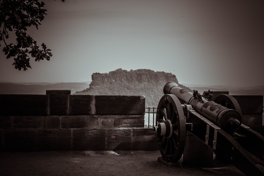 a cannon on a wall with a mountain in the background