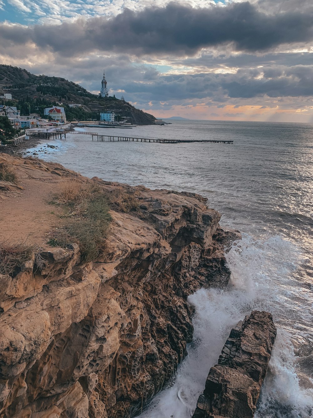 a view of the ocean with a pier in the distance