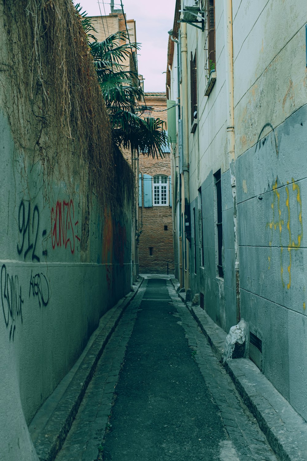 um beco estreito com pichações nas paredes