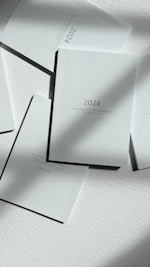 a stack of white books sitting on top of a table