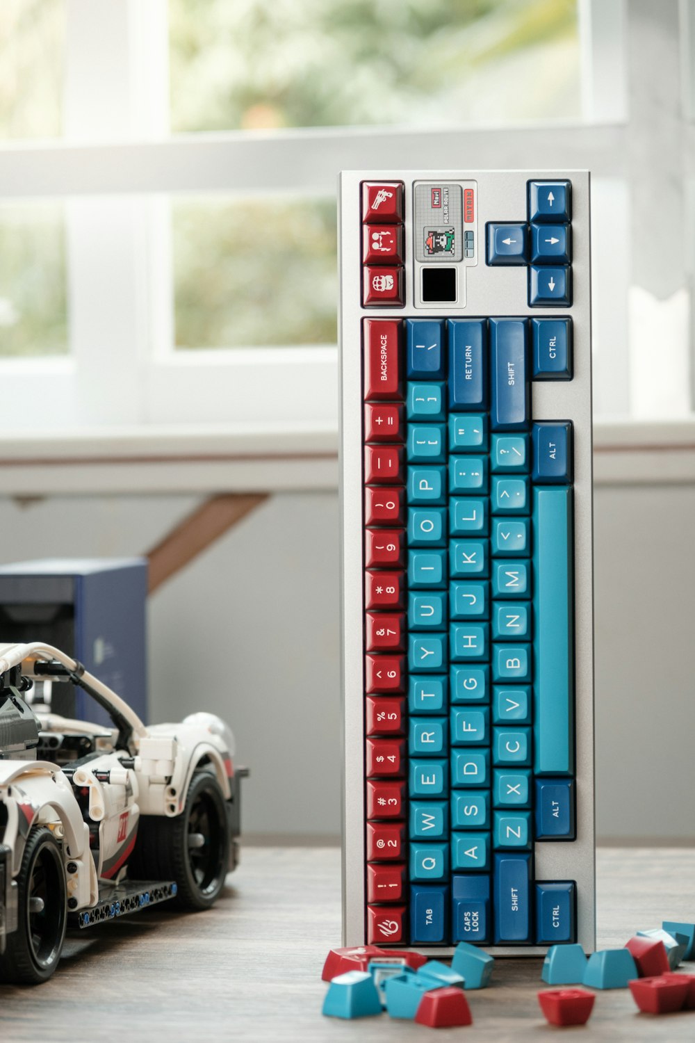 a toy car and a computer keyboard on a table