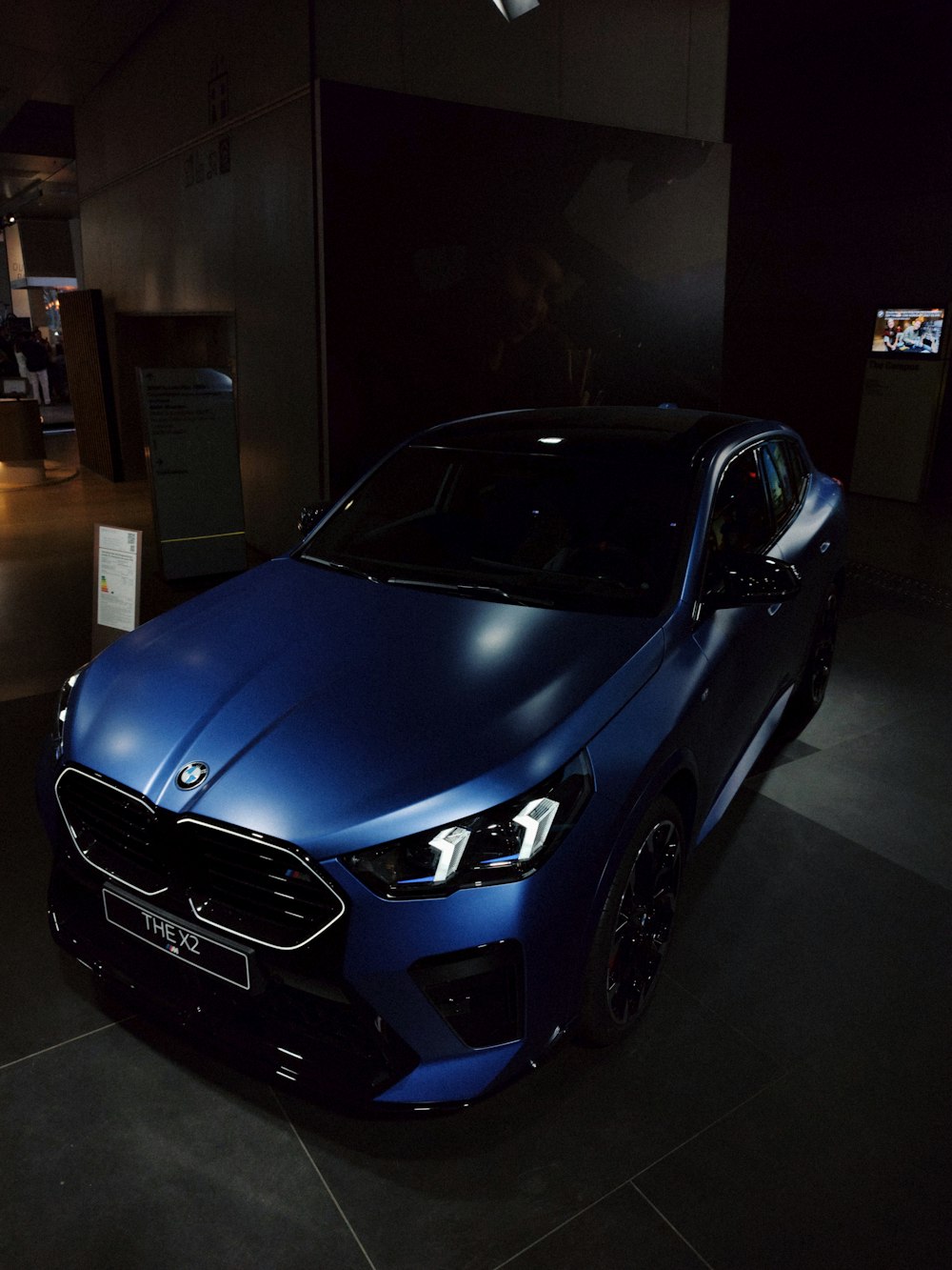 a blue car parked in a dark room