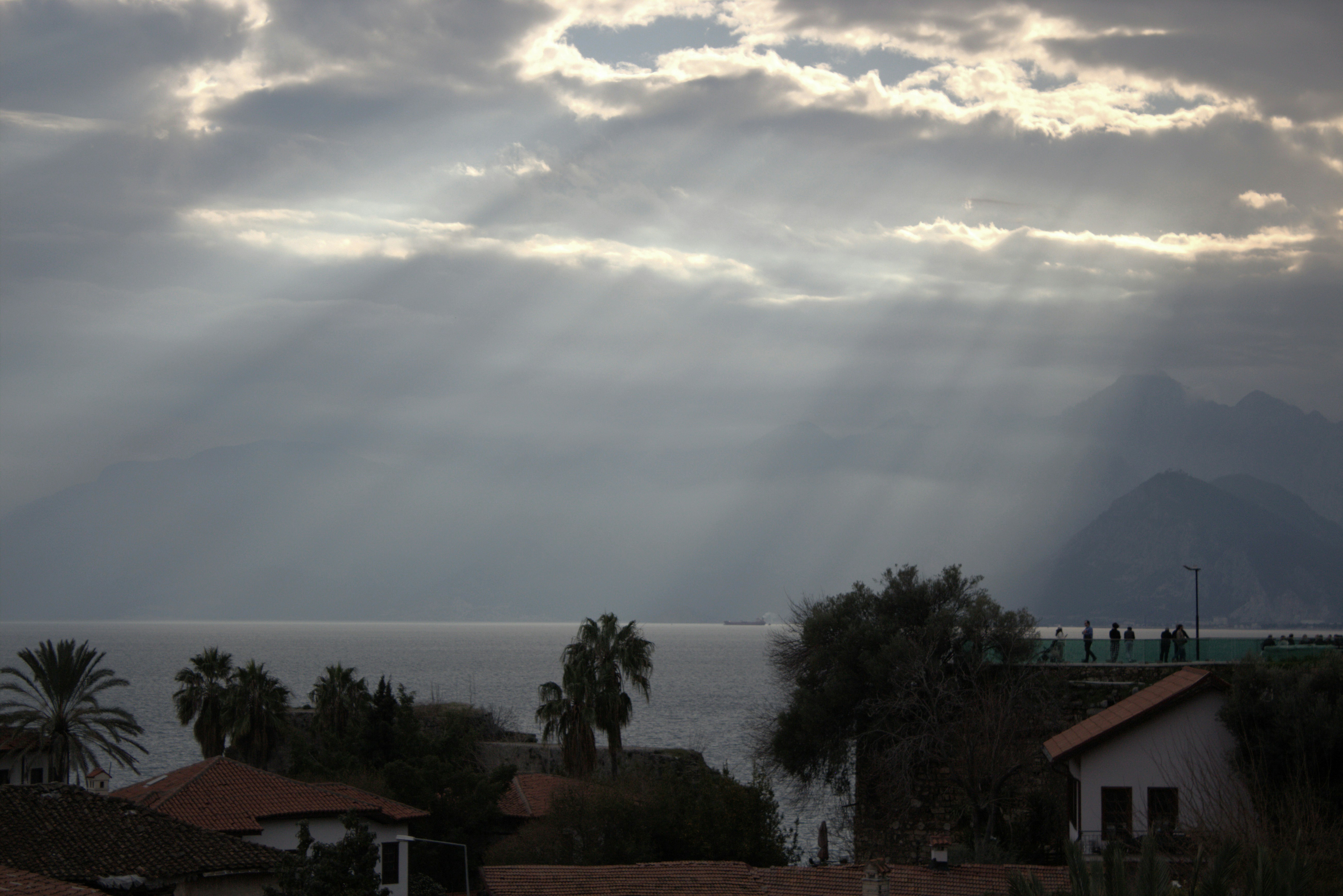 The sun shines through the clouds over a body of water photo – Free ...