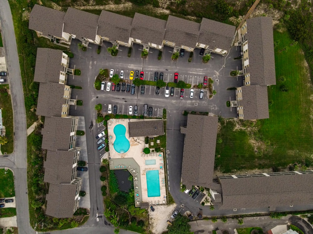 an aerial view of a parking lot with a swimming pool
