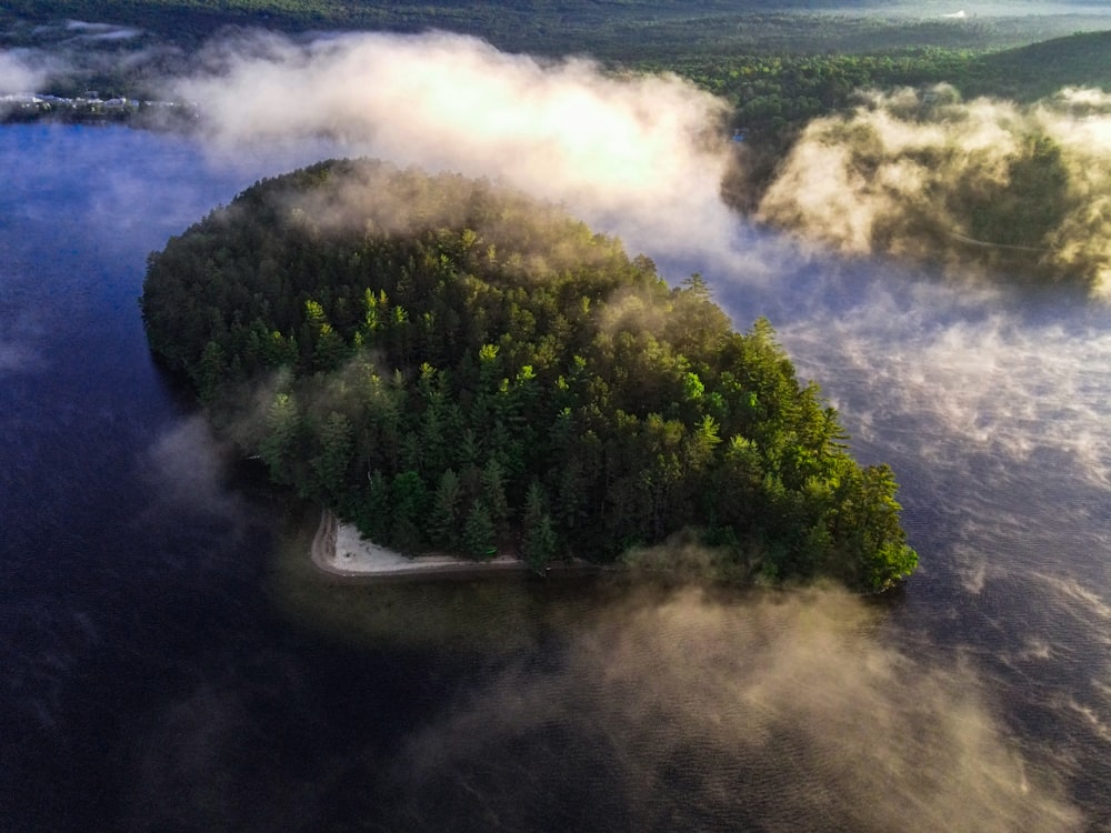 an island in the middle of a lake surrounded by fog