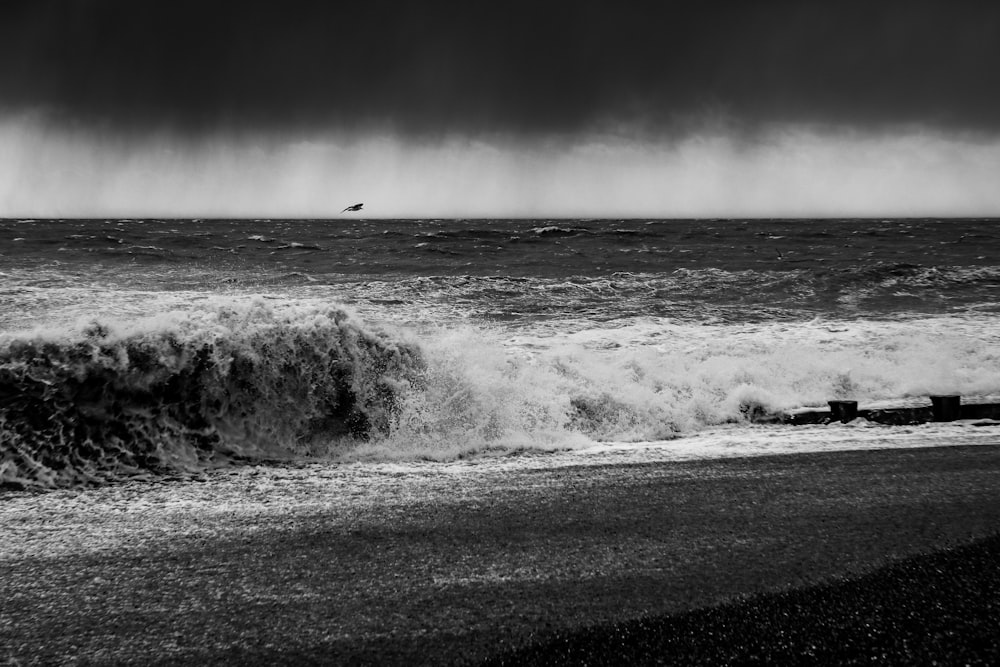 a black and white photo of the ocean with a boat in the distance