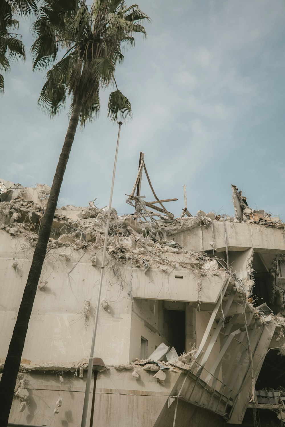 a building that has been demolished with a palm tree in front of it