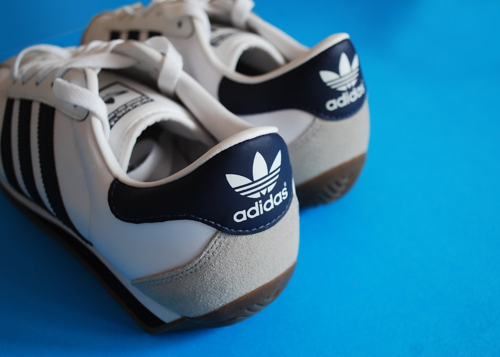 a pair of white and blue adidas sneakers