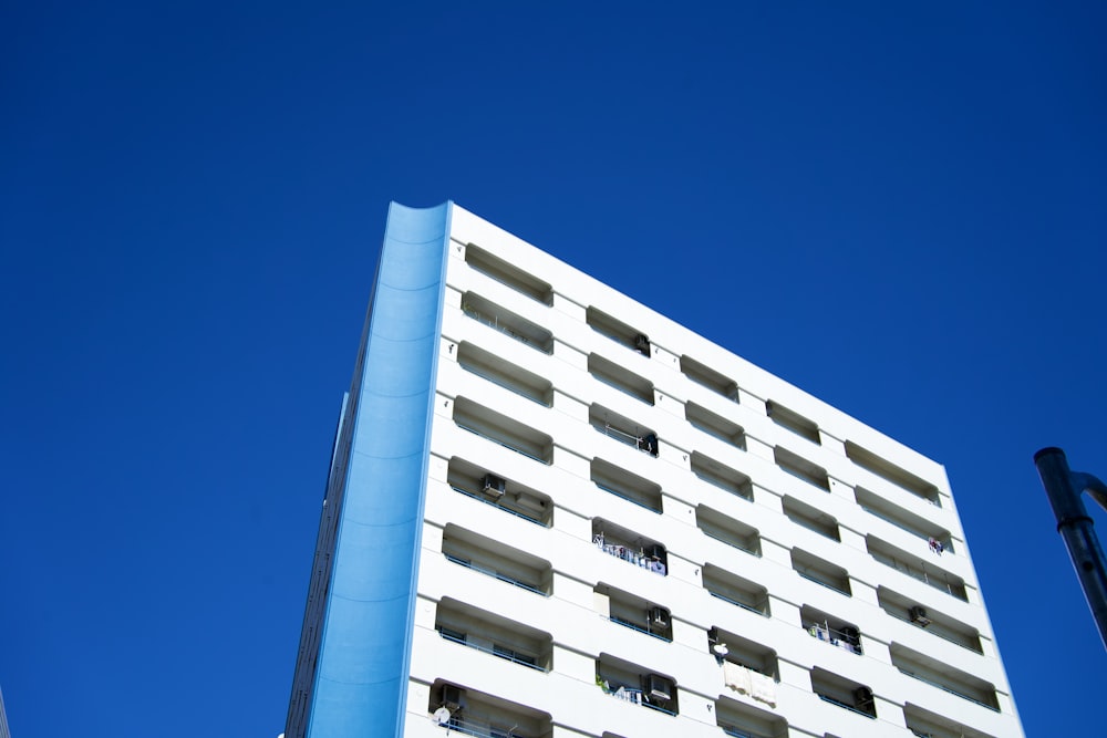 a tall white building sitting next to a tall blue building