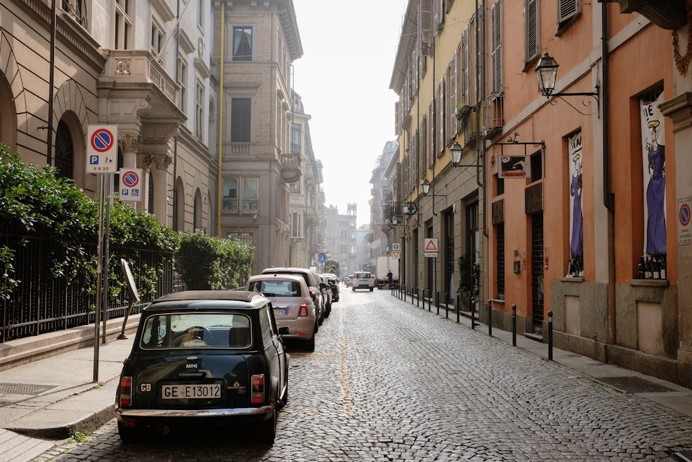 a small car is parked on a cobblestone street