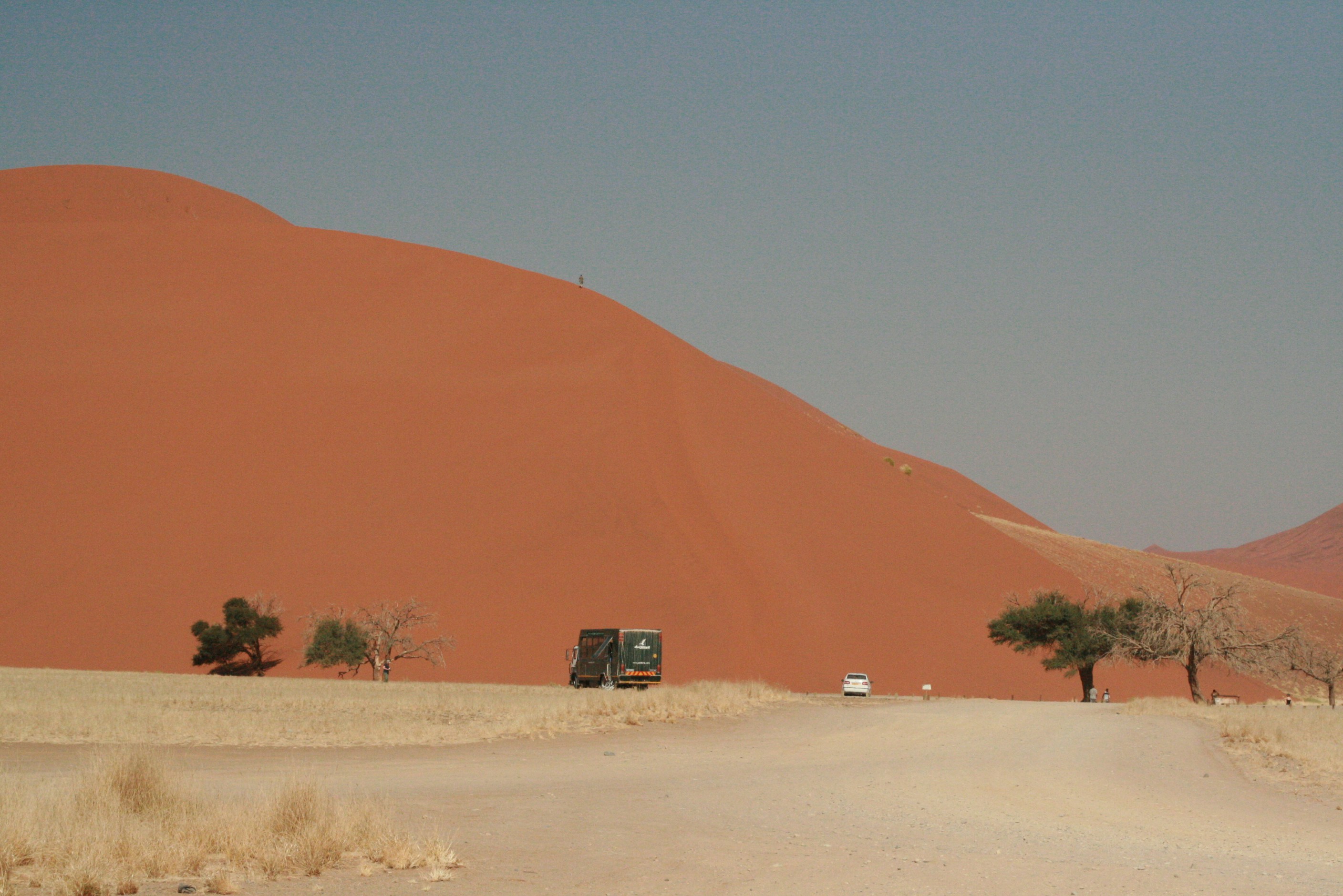 a truck driving down a dirt road in the desert
