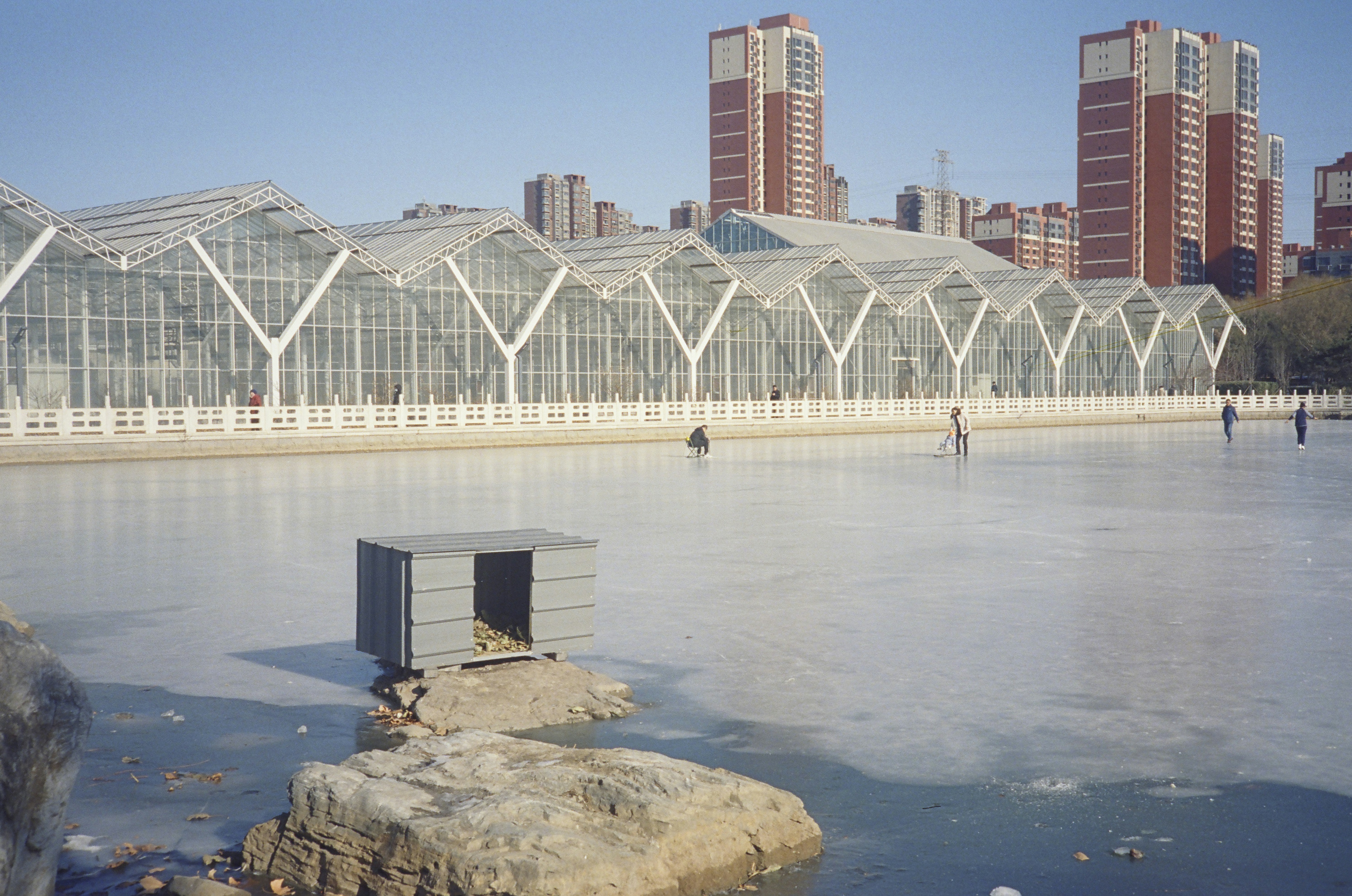 a building with a glass roof next to a body of water