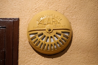 a yellow fire hydrant sitting on the side of a building