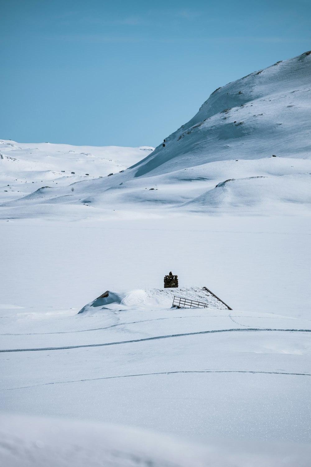 a snow covered field with a ladder in the middle of it