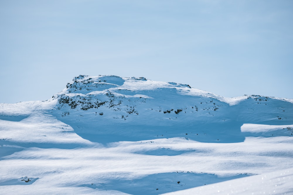 a mountain covered in snow under a blue sky