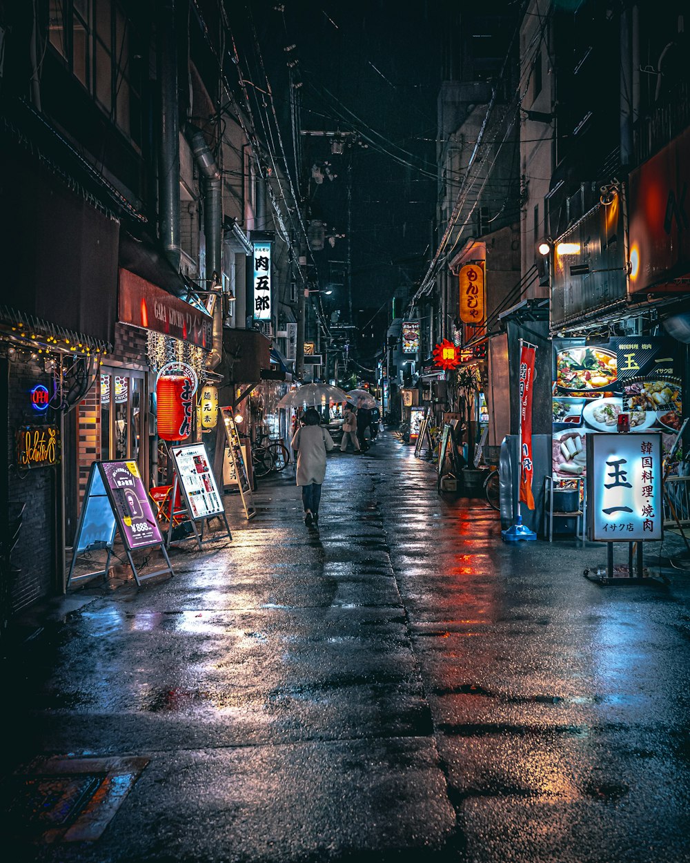 a person walking down a street at night