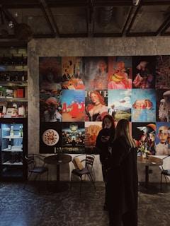 a woman standing in front of a wall covered in pictures