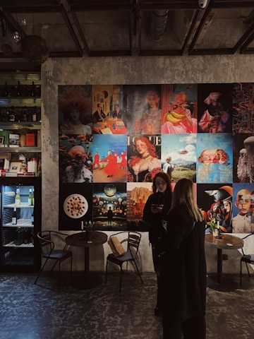 a woman standing in front of a wall covered in pictures