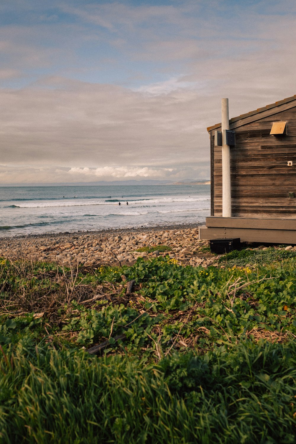 a wooden building sitting on top of a lush green field