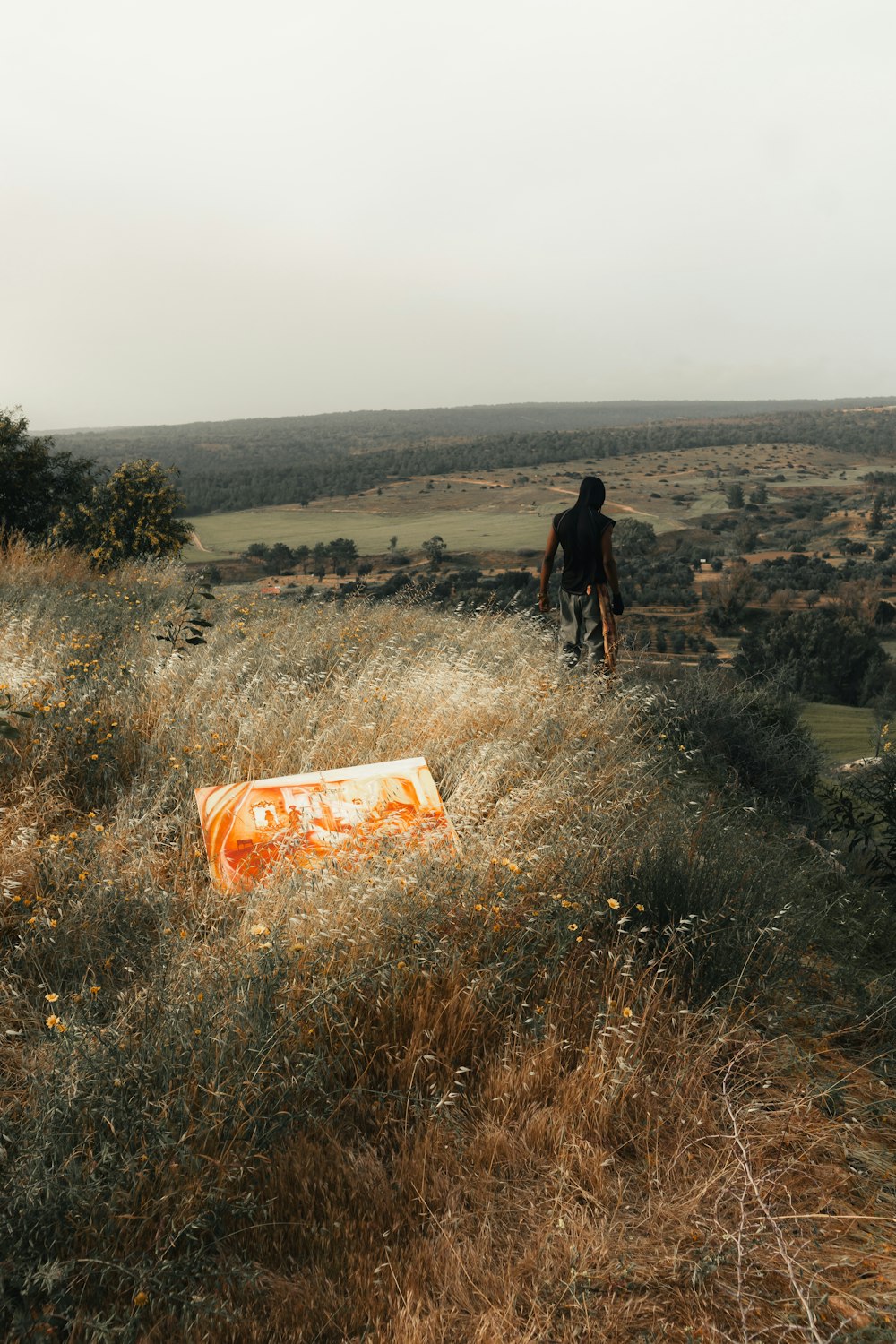 a man riding a bike down a hill next to tall grass