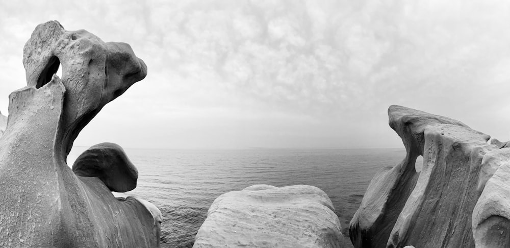 a black and white photo of some rocks by the water