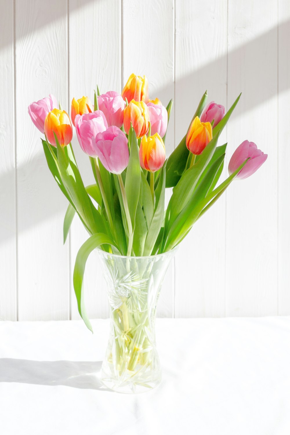 a vase filled with lots of pink and yellow flowers