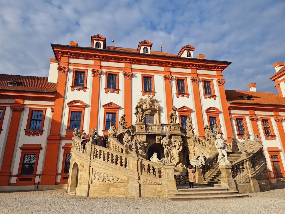 an orange and white building with a fountain in front of it