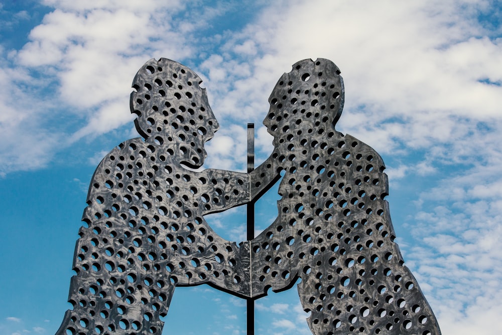 a sculpture of two people touching each other