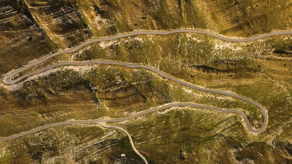 an aerial view of a winding road in the mountains