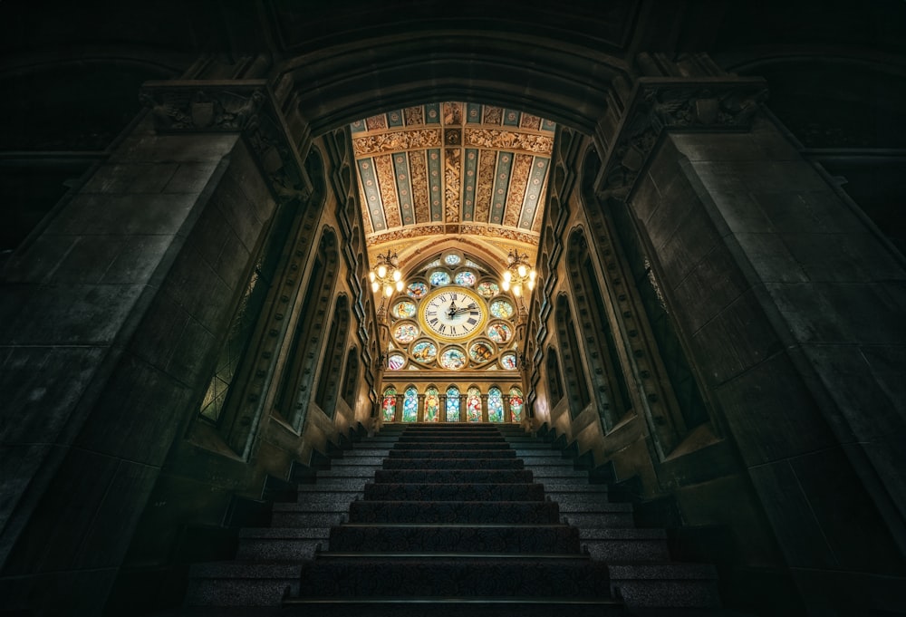 a staircase leading up to a large stained glass window