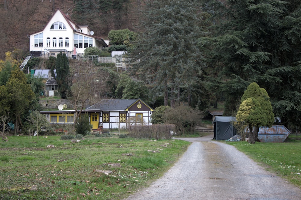 a dirt road leading to a white house