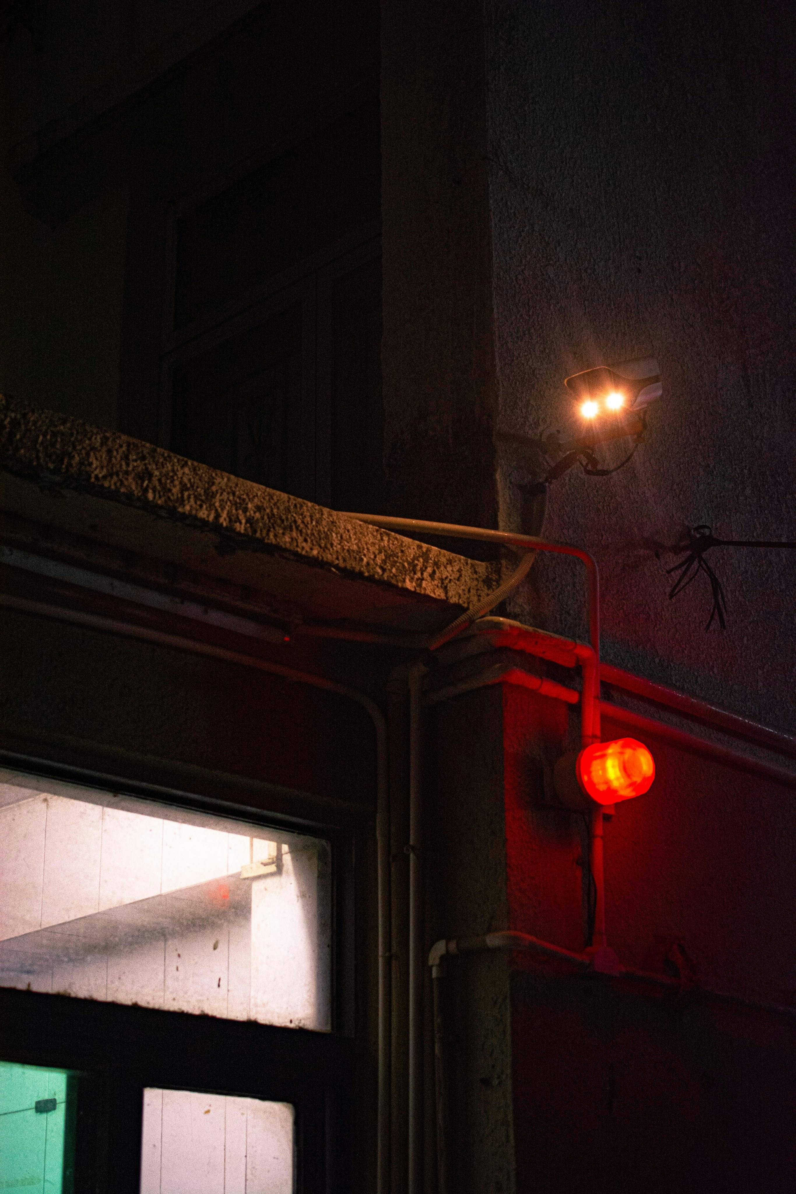 a red stop light sitting on the side of a building