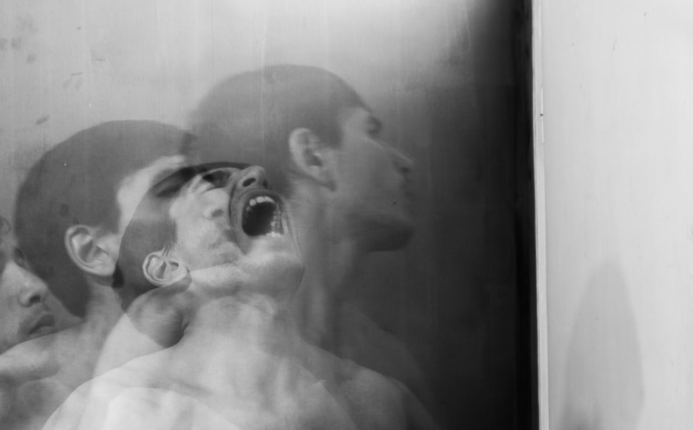 a black and white photo of two men with their mouths open