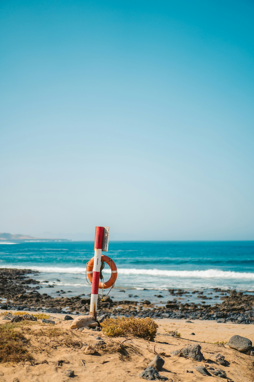 a life preserver on a beach with the ocean in the background