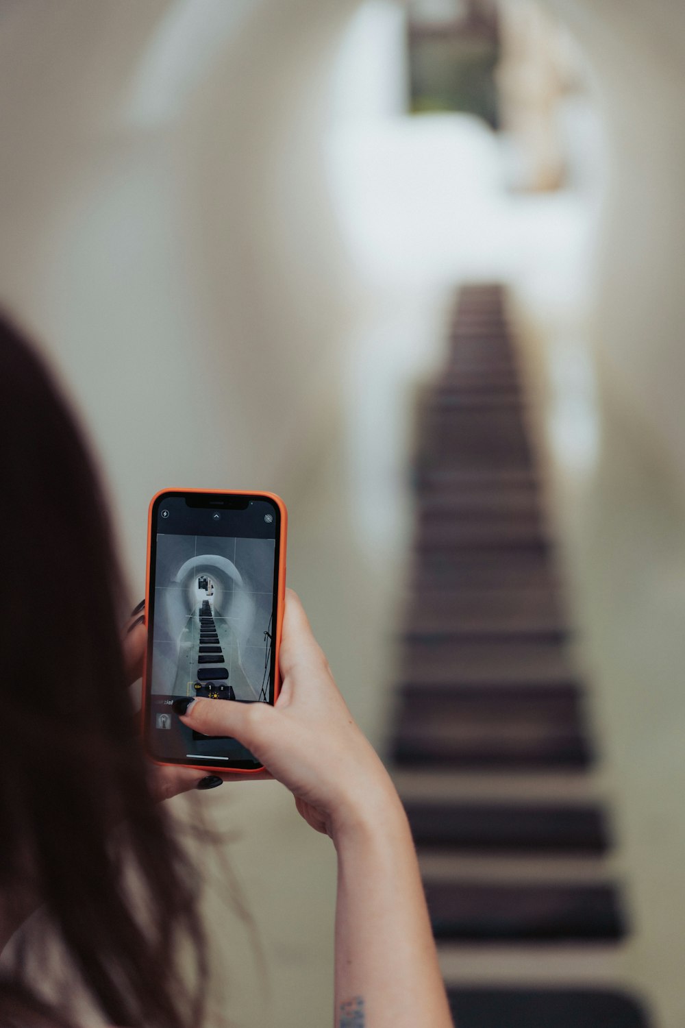 a woman taking a picture of a stairway