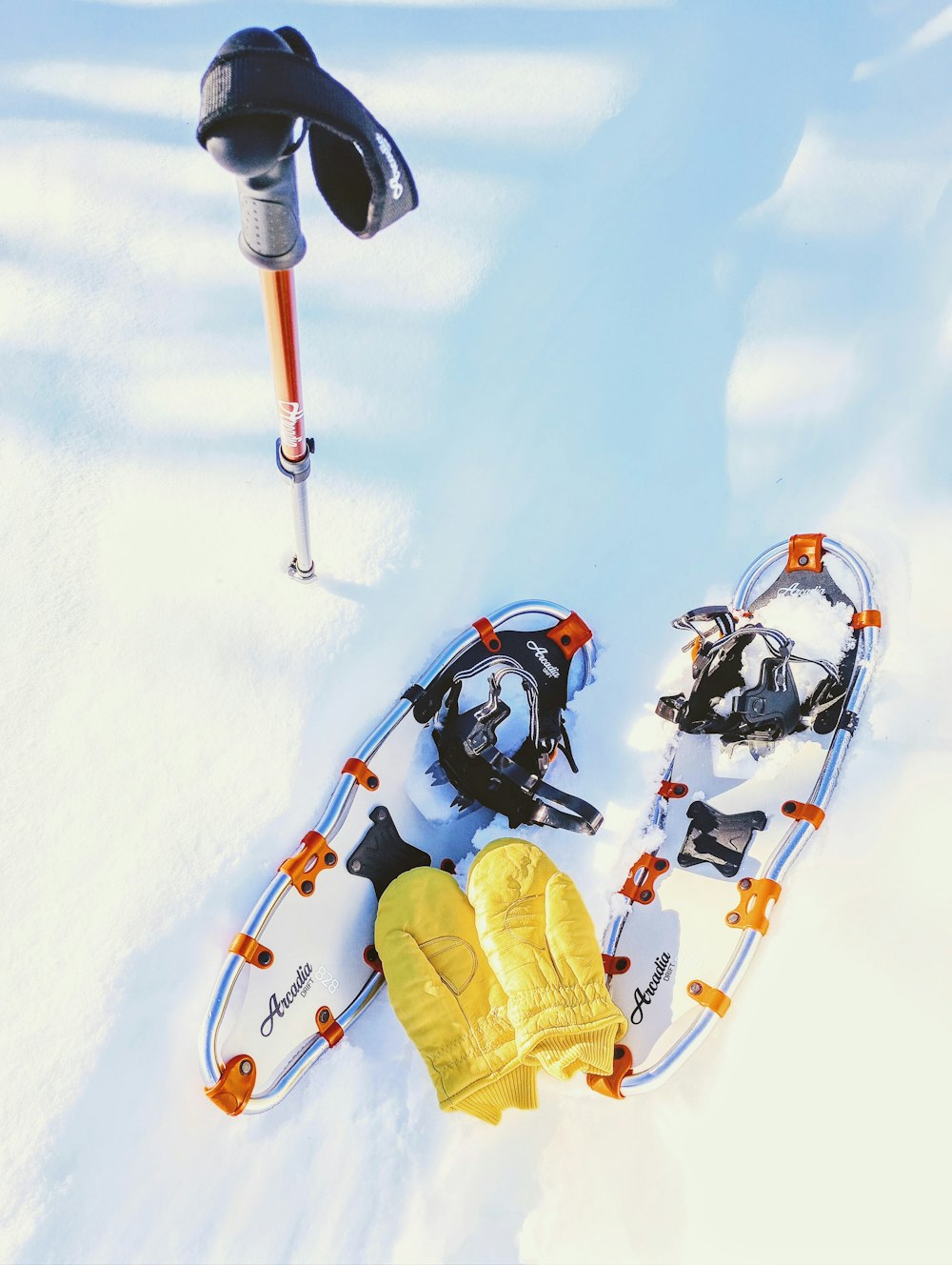 a pair of skis and gloves laying in the snow