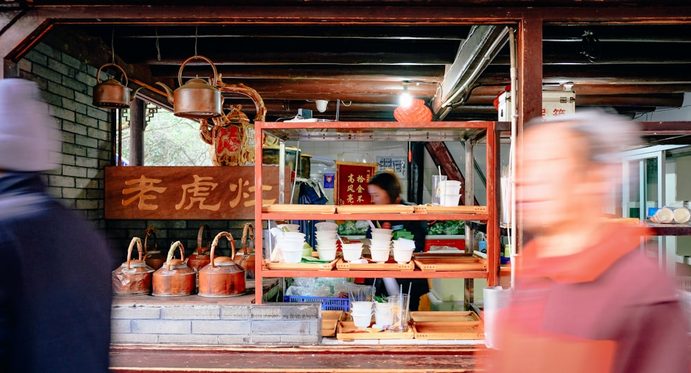 a man standing in front of a store filled with items