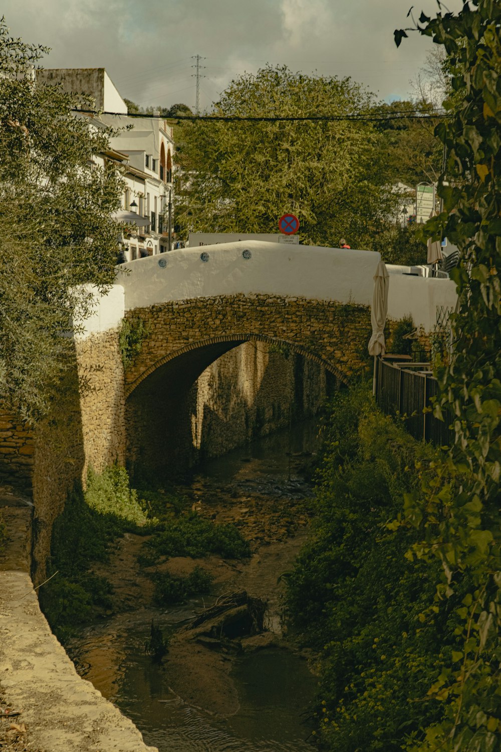 a stone bridge over a small stream in a city