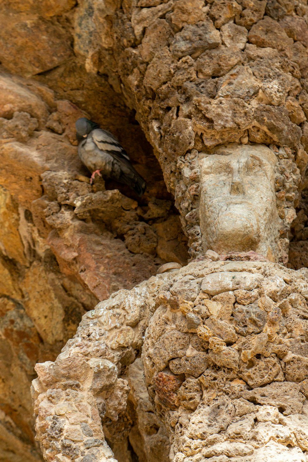 a bird is perched on a stone statue