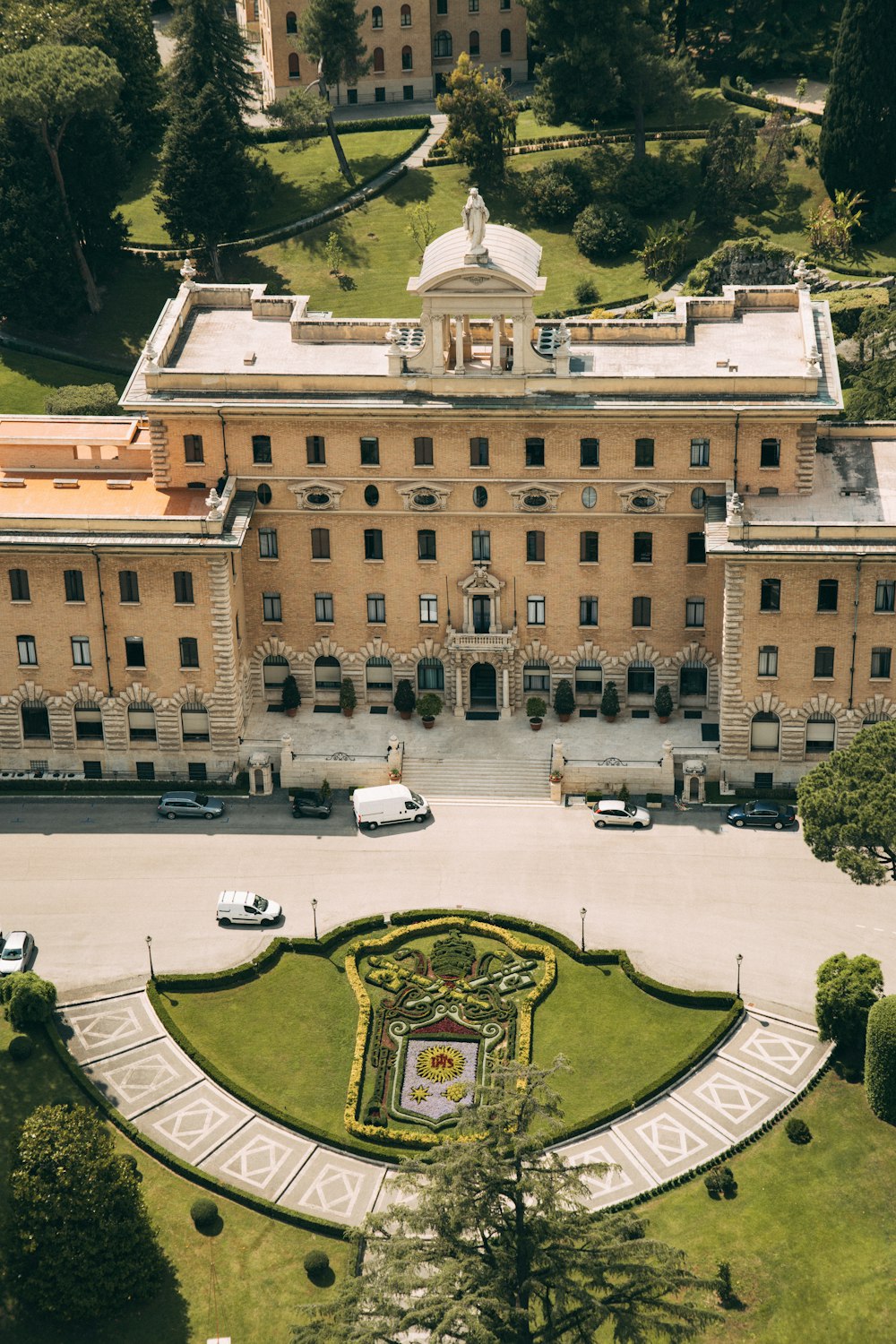 an aerial view of a large building with a garden in front of it