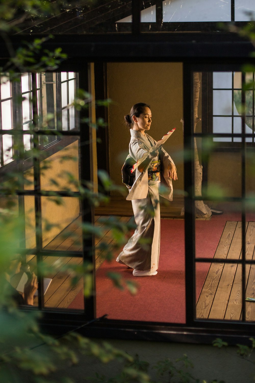 una mujer con kimono de pie en el umbral de una puerta