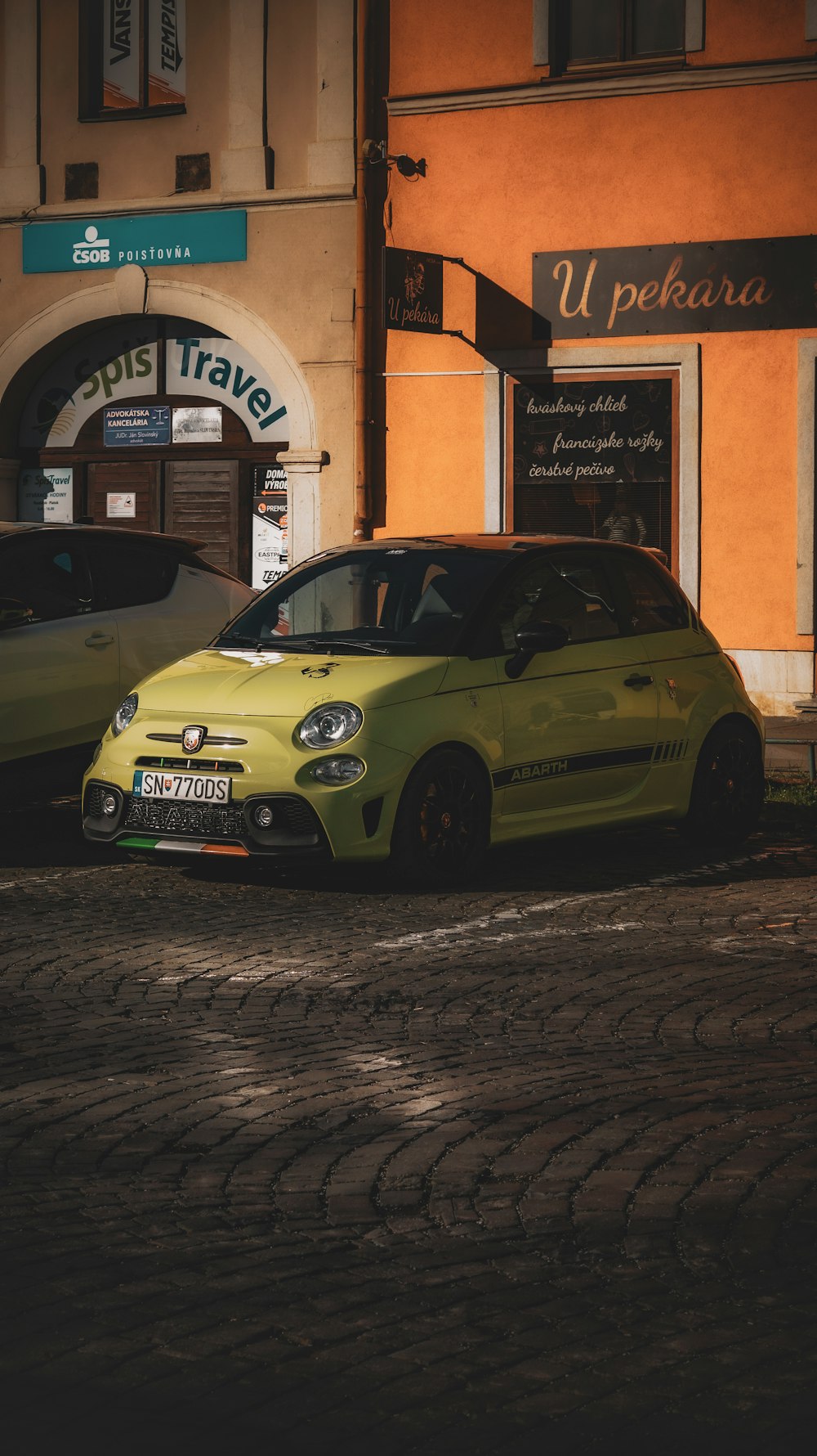 a small yellow car parked in front of a building