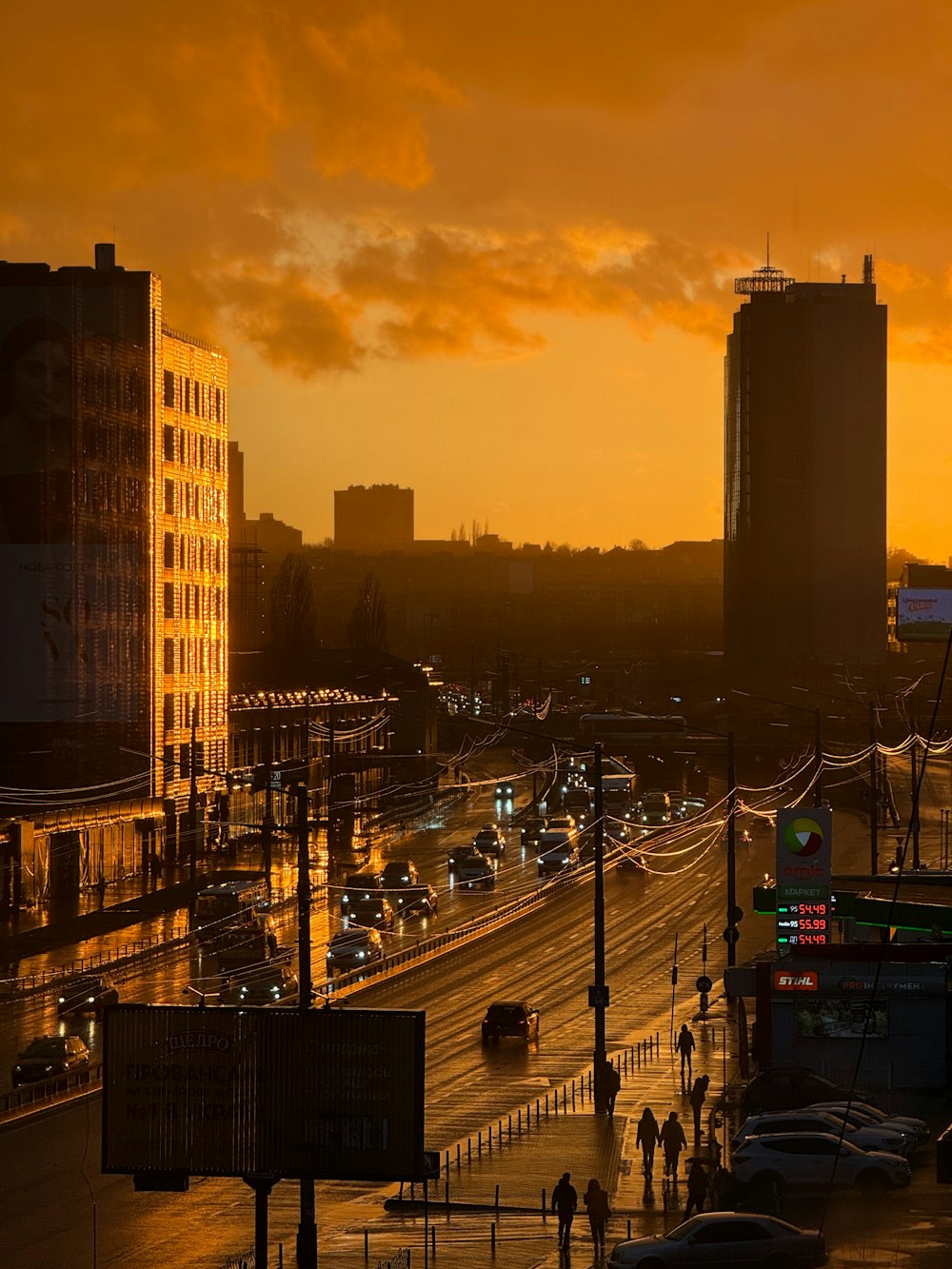 a city street at sunset with cars driving on it