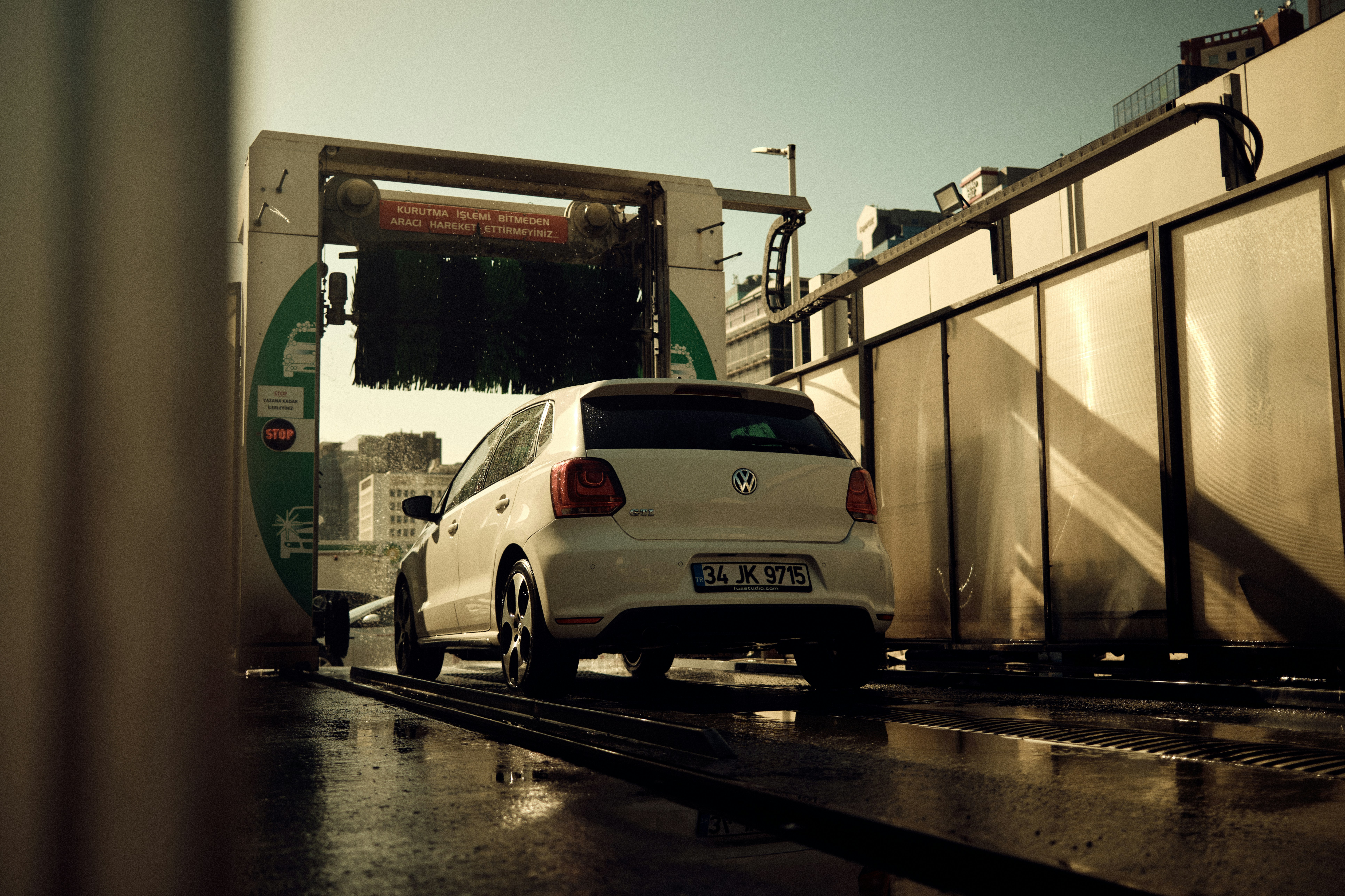 a white car is parked in front of a train