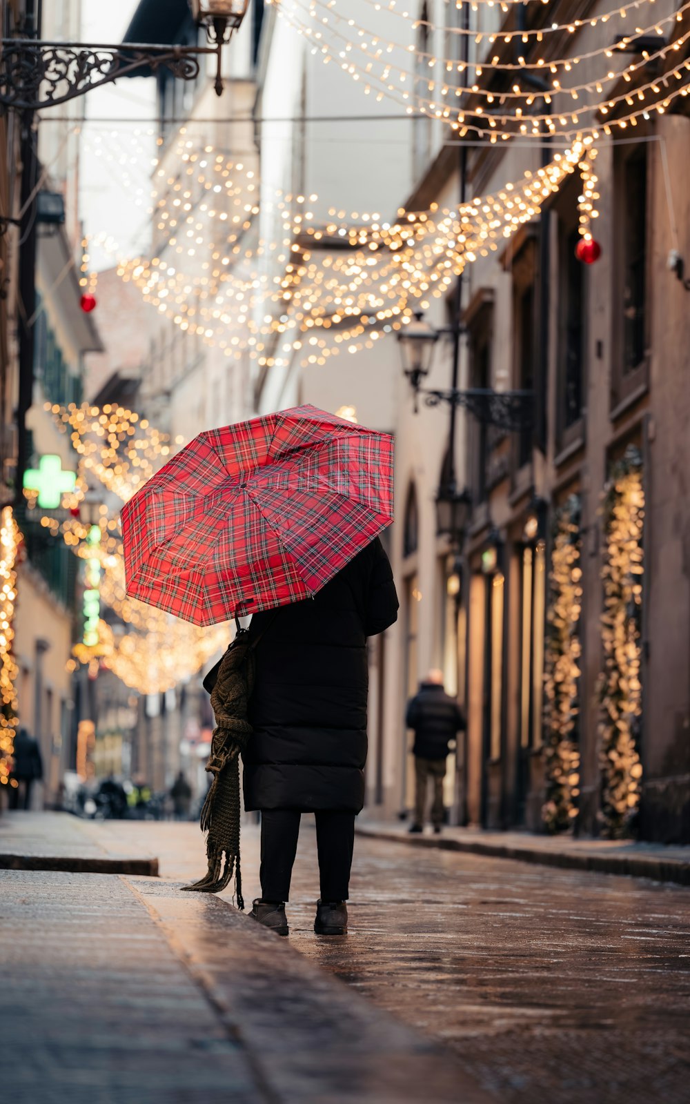 a person walking down a street holding an umbrella